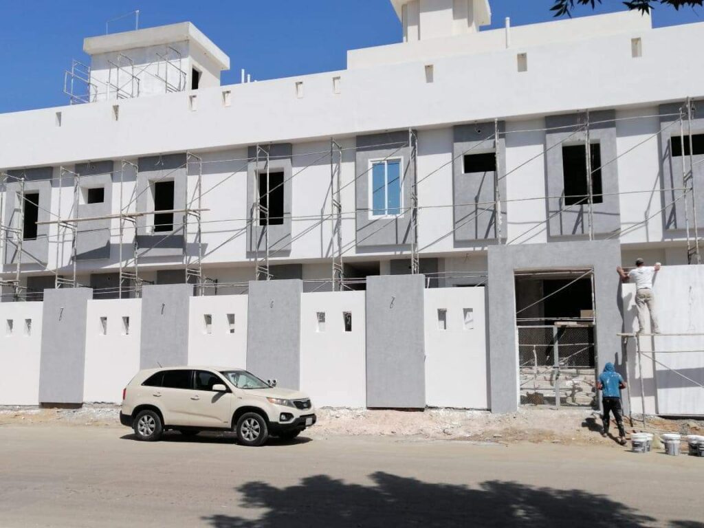 فني متخصص يقوم بترميم وتعبئة شقوق الجدران العميقة في مبنى سكني